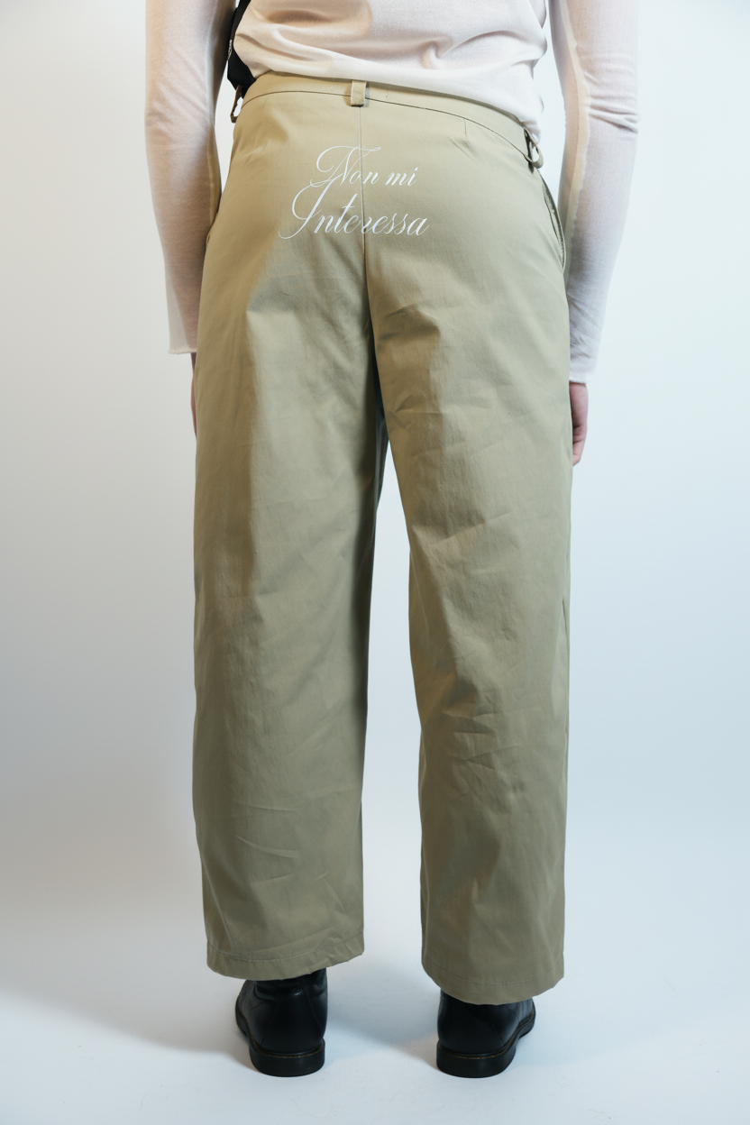 Person wearing beige pants with "Non mi Interessa" print on a white background